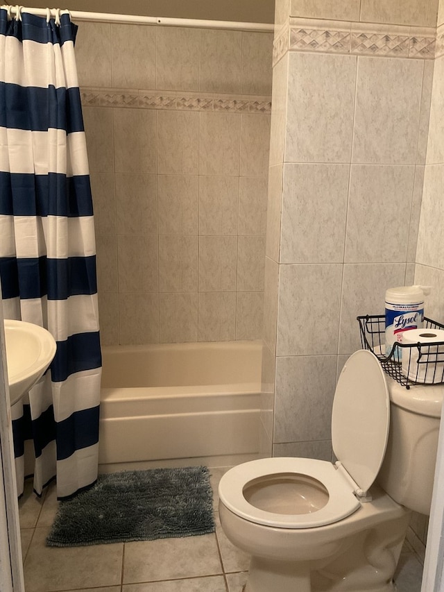 bathroom featuring shower / bath combo, toilet, tile patterned flooring, and tile walls