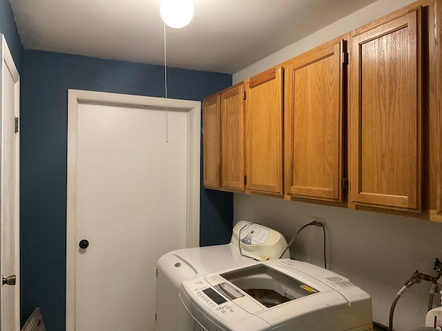 washroom featuring washer and clothes dryer and cabinets