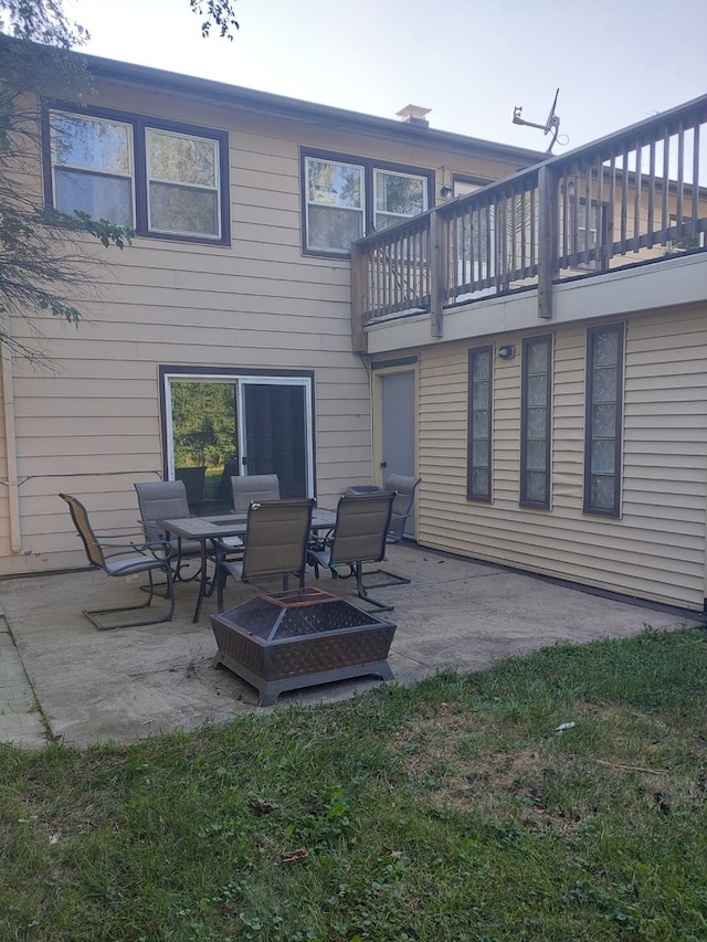 back of property with an outdoor fire pit and a patio area