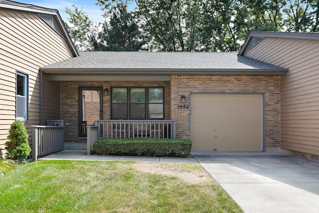 view of front of property with a garage, covered porch, and a front lawn