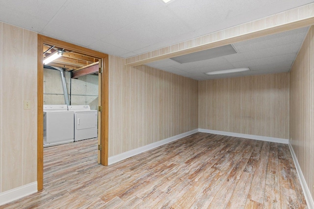 empty room featuring hardwood / wood-style flooring, separate washer and dryer, and a drop ceiling