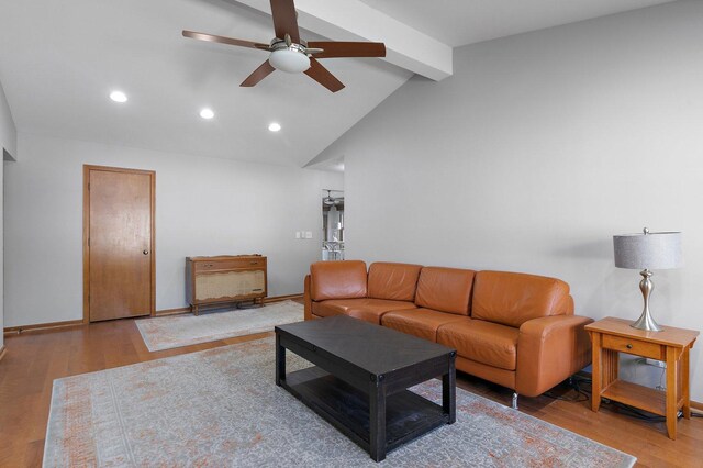 living room with ceiling fan, vaulted ceiling with beams, and hardwood / wood-style floors