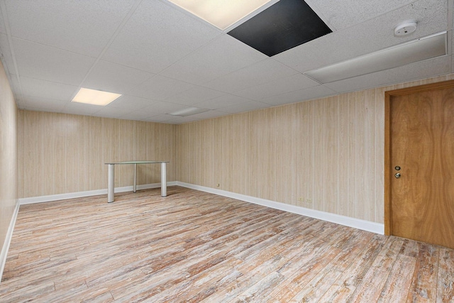 basement with a paneled ceiling and hardwood / wood-style floors