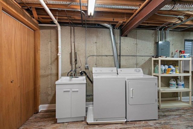 laundry area with sink, hardwood / wood-style floors, electric panel, and washer and clothes dryer