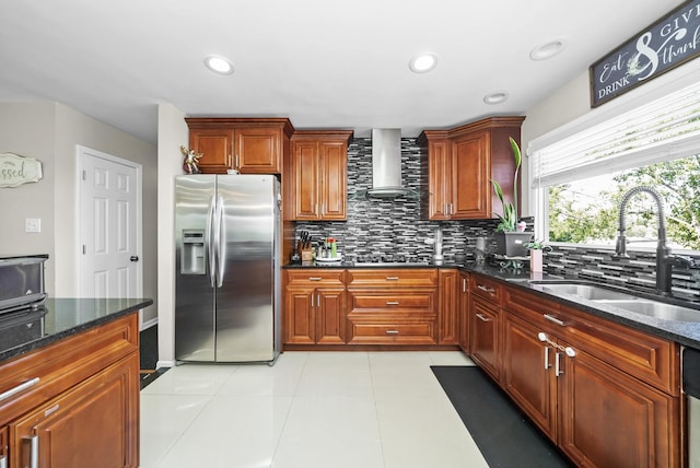 kitchen featuring appliances with stainless steel finishes, sink, decorative backsplash, dark stone counters, and wall chimney exhaust hood