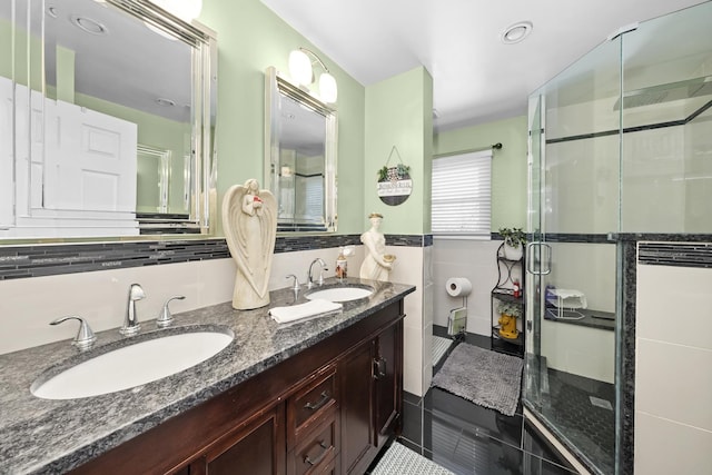 bathroom featuring tile patterned floors, a shower with shower door, vanity, and tile walls