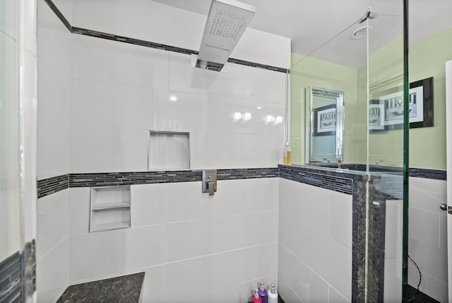 bathroom with a tile shower and tile walls