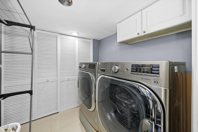 laundry room with washer and dryer, light tile patterned floors, and cabinets