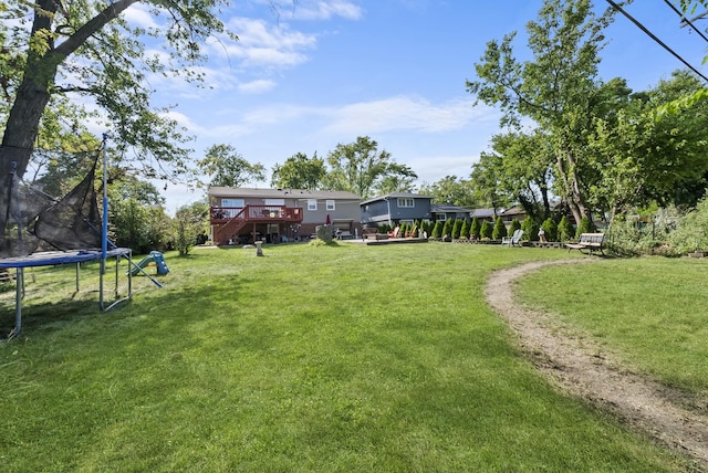 view of yard with a deck and a trampoline