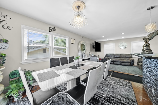 dining area with hardwood / wood-style floors and a chandelier