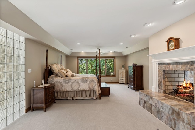 bedroom featuring recessed lighting, light colored carpet, a fireplace, and baseboards