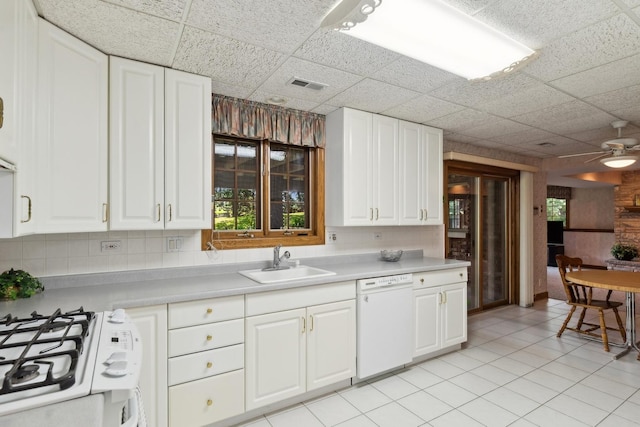 kitchen featuring light countertops, visible vents, white cabinetry, a sink, and white appliances