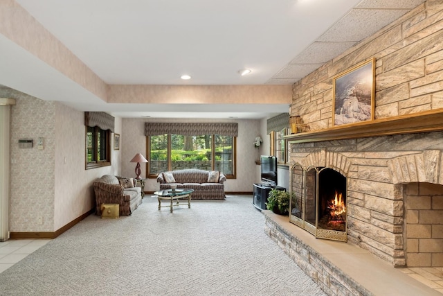 living area featuring baseboards, a fireplace, light carpet, and wallpapered walls