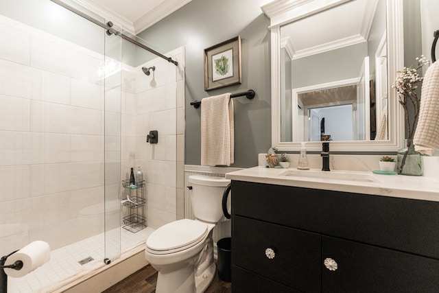 bathroom with a shower with shower door, toilet, crown molding, hardwood / wood-style flooring, and vanity