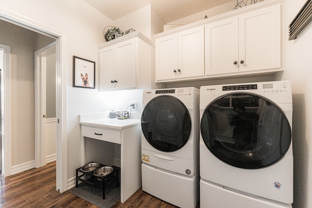 laundry area with dark hardwood / wood-style flooring, washing machine and clothes dryer, and cabinets