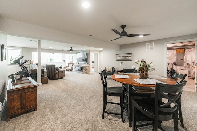 dining area with ceiling fan and light carpet