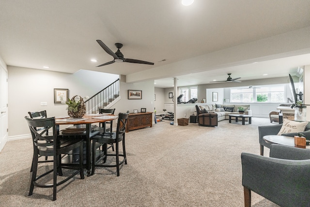 carpeted dining space with ceiling fan