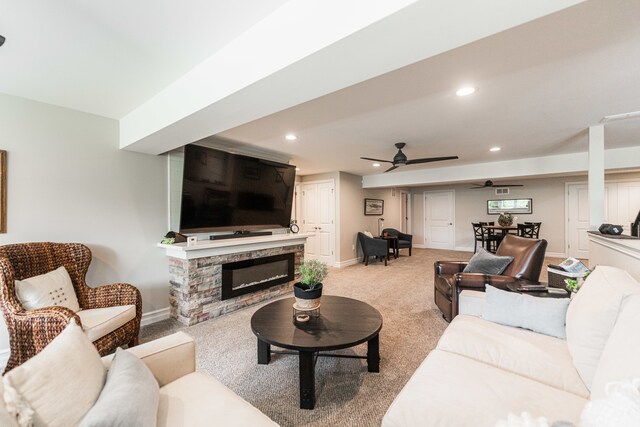 carpeted living room featuring ceiling fan and a fireplace