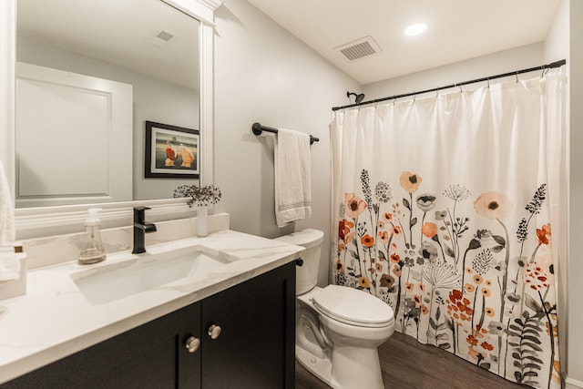 bathroom with hardwood / wood-style flooring, vanity, and toilet