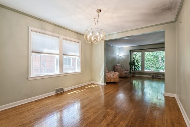 unfurnished dining area featuring wood-type flooring, a notable chandelier, and ornamental molding