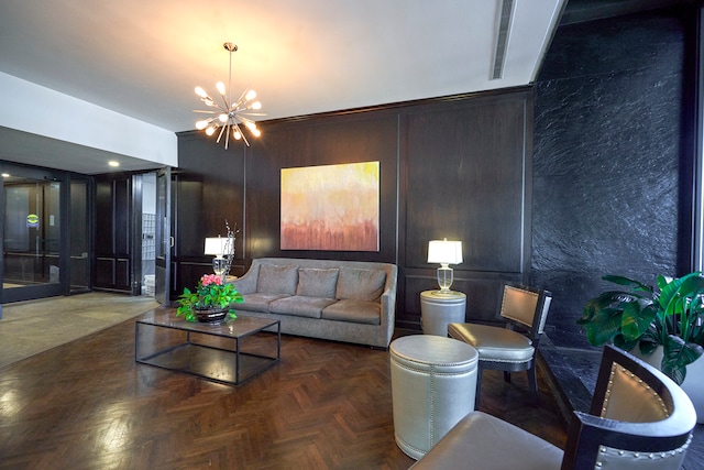 living room featuring a notable chandelier, wood walls, and parquet floors