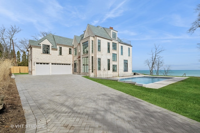 exterior space with a garage, a front yard, and a water view