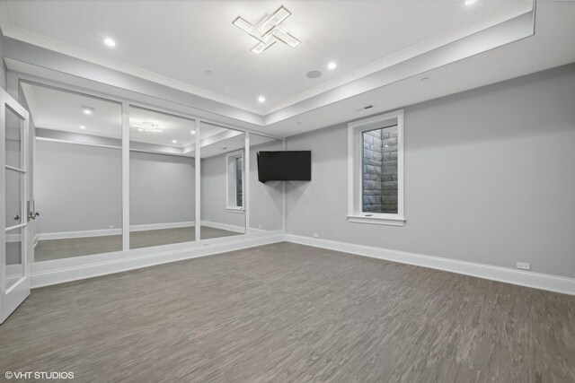 basement with ornamental molding and hardwood / wood-style floors