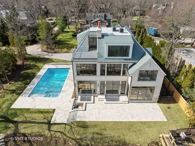 rear view of property with a lawn, a fenced in pool, and a patio area