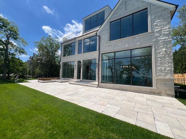 back of property featuring a patio and a yard