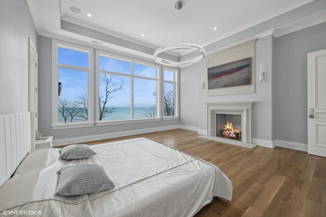 bedroom featuring radiator, hardwood / wood-style flooring, and a raised ceiling