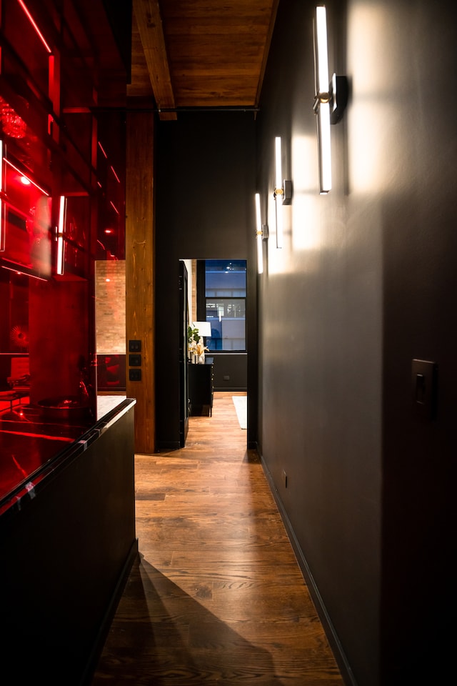 corridor featuring beamed ceiling, light wood-type flooring, and wood ceiling