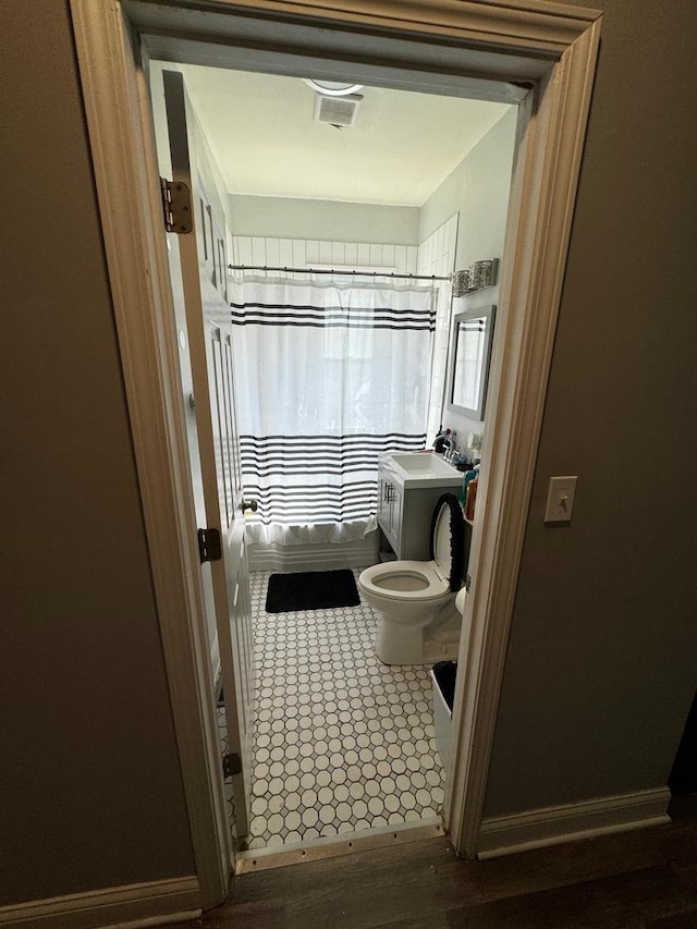 bathroom featuring hardwood / wood-style flooring, toilet, and a shower with shower curtain