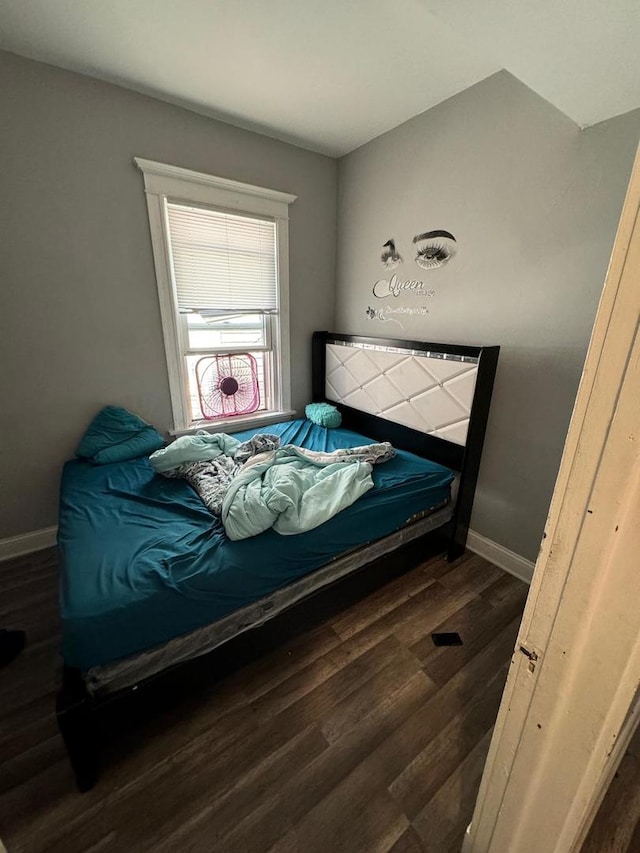 bedroom with dark hardwood / wood-style flooring