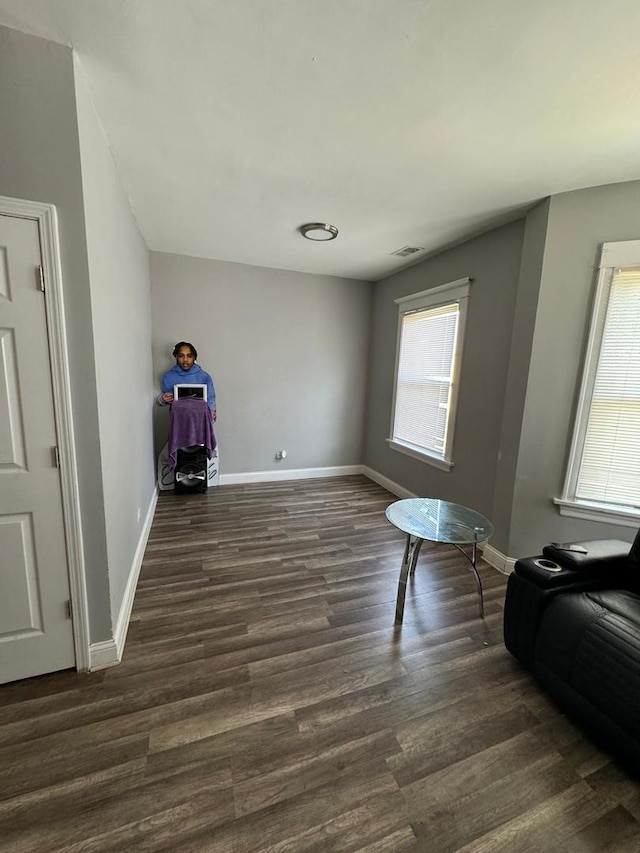 sitting room with dark hardwood / wood-style flooring and a healthy amount of sunlight