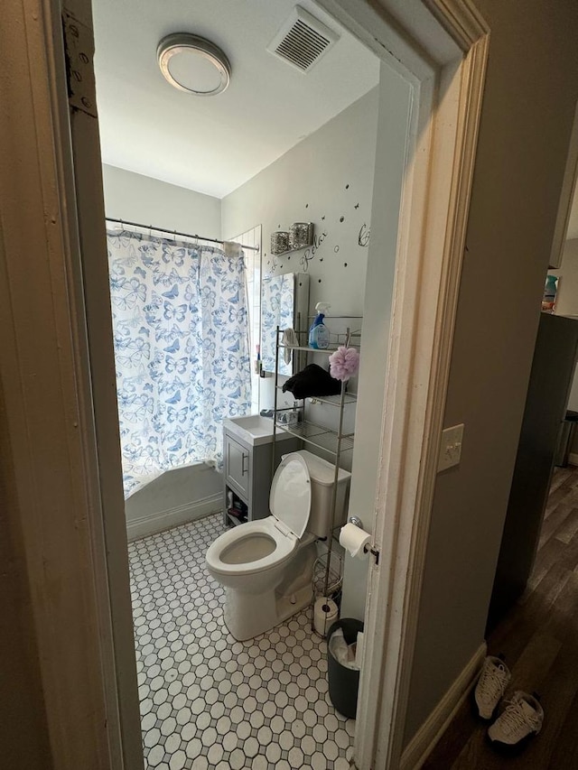 bathroom featuring walk in shower, vanity, and toilet