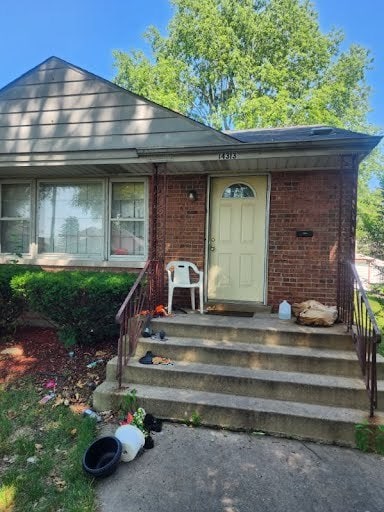 view of exterior entry with brick siding