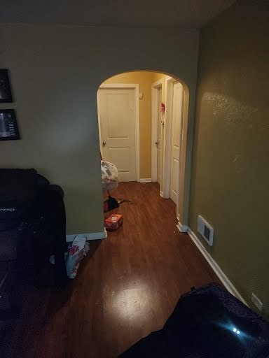 14313 S Eggleston Ave, Riverdale, IL 60827 - corridor with baseboards, visible vents, arched walkways, and wood finished floors