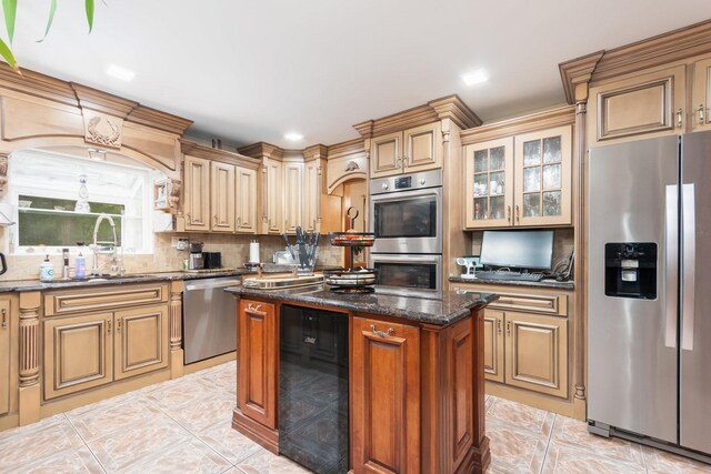 kitchen featuring appliances with stainless steel finishes, tasteful backsplash, light tile patterned floors, dark stone counters, and a kitchen island