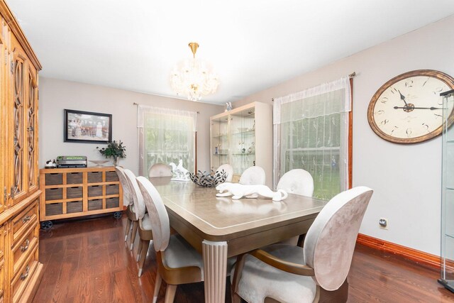 dining area with a notable chandelier and dark hardwood / wood-style flooring