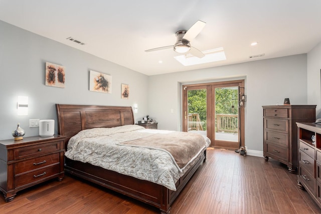 bedroom with ceiling fan, dark hardwood / wood-style flooring, access to exterior, and a skylight