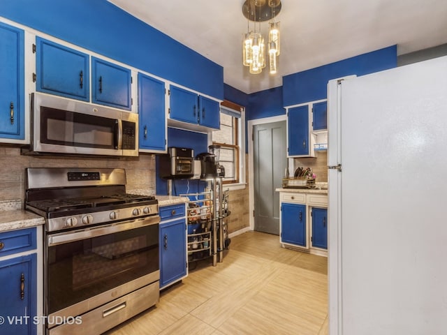 kitchen with appliances with stainless steel finishes, blue cabinets, and backsplash