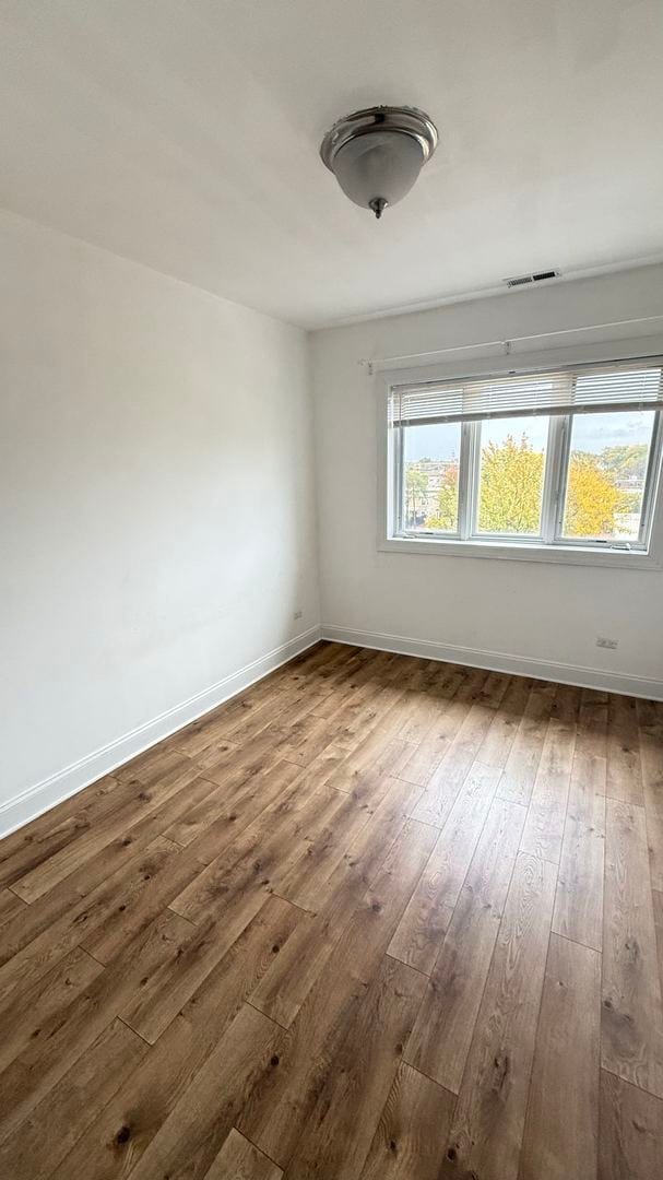 unfurnished room with hardwood / wood-style flooring