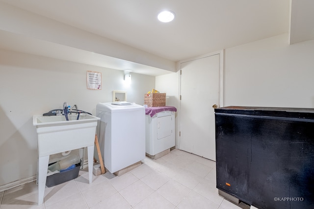 clothes washing area with washer and dryer and light tile patterned floors