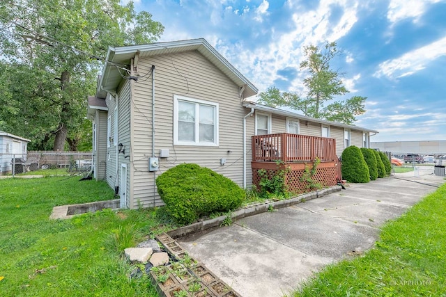 view of home's exterior with a deck and a lawn