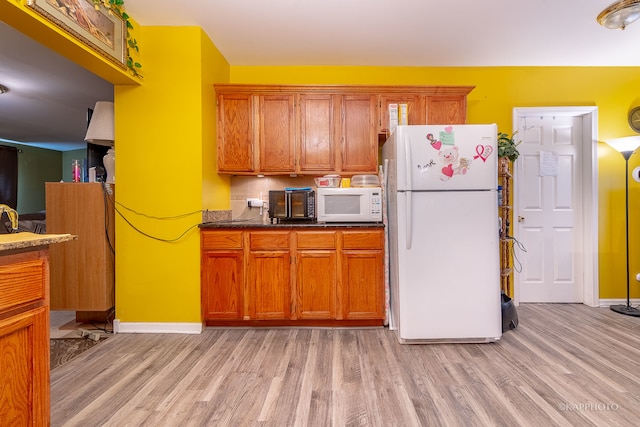 kitchen featuring light hardwood / wood-style floors and white appliances