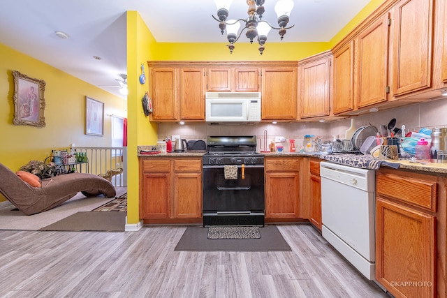 kitchen featuring white appliances, light hardwood / wood-style floors, a notable chandelier, and tasteful backsplash