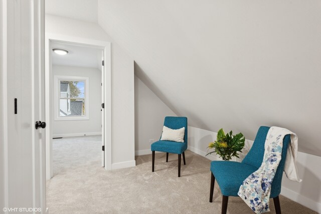 sitting room with lofted ceiling and light carpet