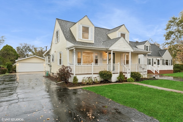 cape cod-style house featuring a front yard, covered porch, an outdoor structure, and a garage