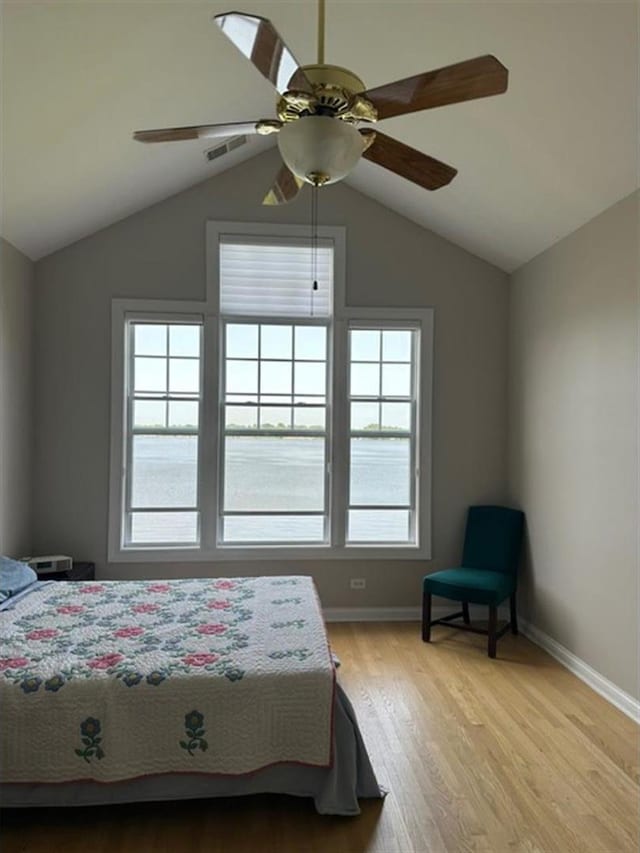 unfurnished bedroom featuring ceiling fan, light hardwood / wood-style flooring, multiple windows, and lofted ceiling