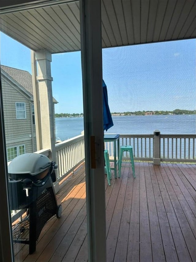 wooden deck with area for grilling and a water view